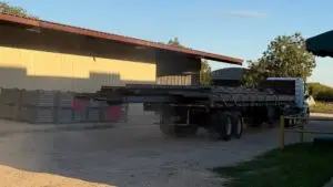 Flatbed loaded with fabricated structural steel leaving the Heartland Steel yard in Woodway, TX