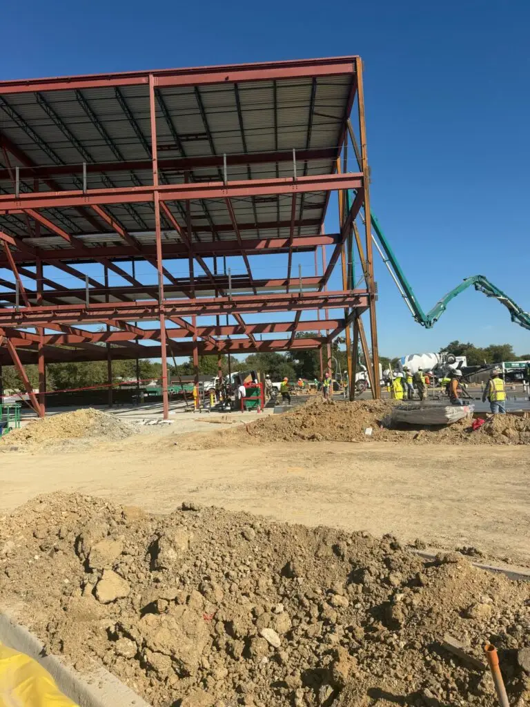 Structural steel frame during a concrete pour in Frisco, TX
